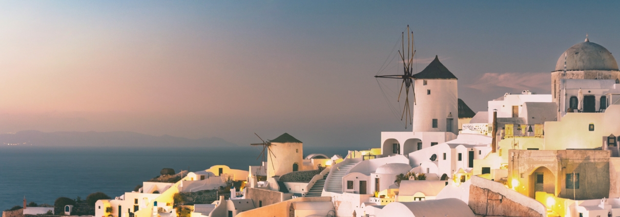 Whitewashed buildings and blue-domed churches overlooking the Aegean Sea in Santorini, Greece, a stunning stop on multi-country European trips