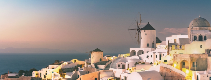 Whitewashed buildings and blue-domed churches overlooking the Aegean Sea in Santorini, Greece, a stunning stop on multi-country European trips